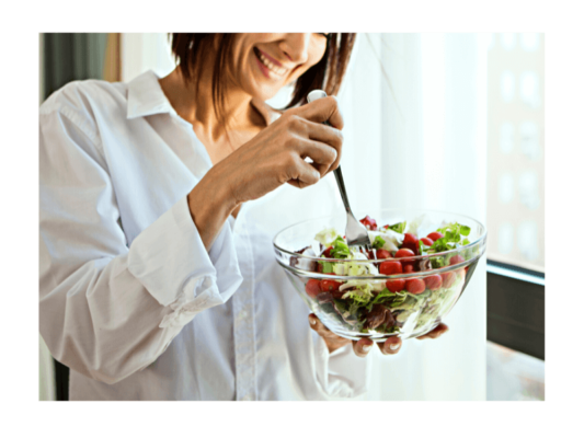 woman smiling about to eat salad because she knows more about food sensativity