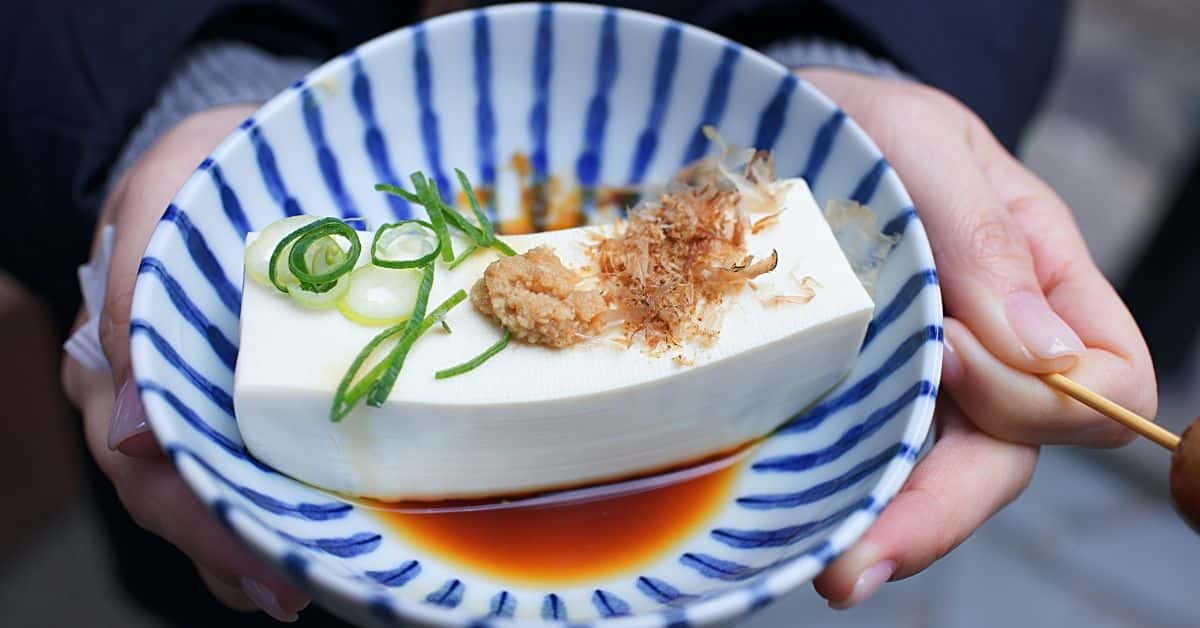 block of tofu with herbs in a striped bowl, soy and ibd