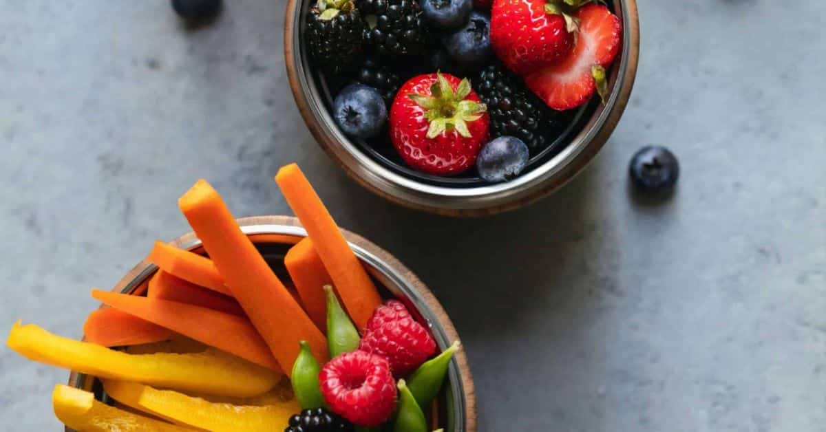 Healthy snacks are pictured including berries and veggies sticks, 10 snacks for ulcerative colitis