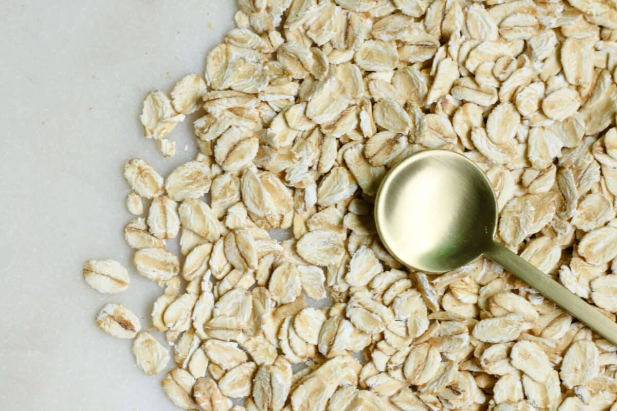 Oats spread on a plate with a golden spoon on top of them
