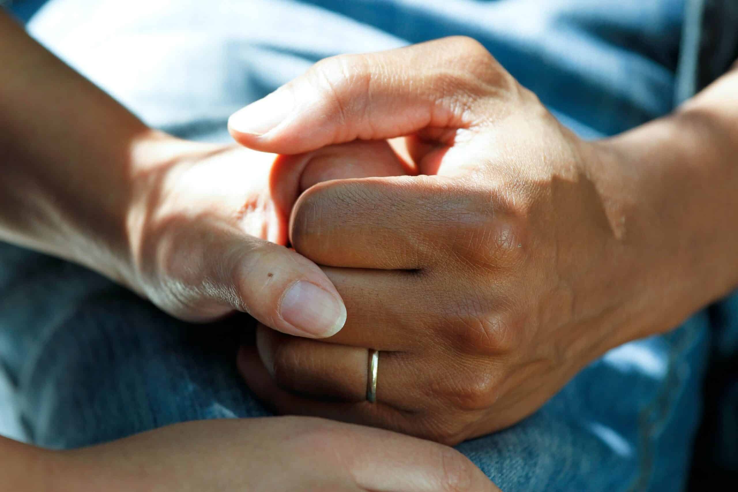 Is Crohn's Disease a Disability? Two hands are held together in a supportive and warm embrace